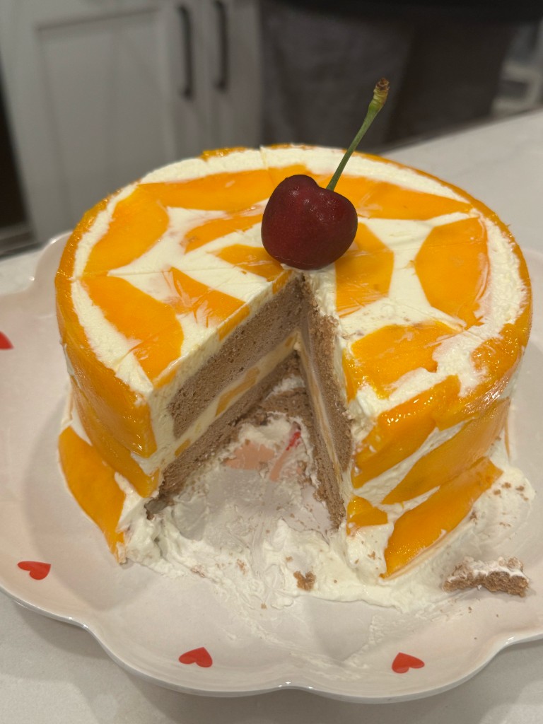A mango cake with a cherry