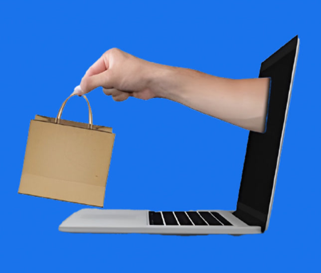 Hand reaching out of a laptop holding a shopping bag