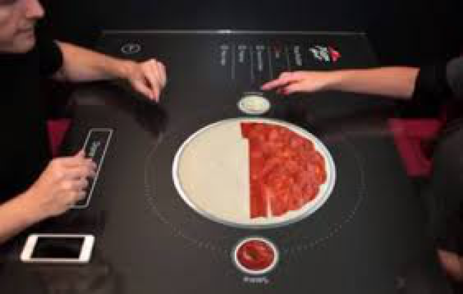 Diners customizing a pizza on the Pizza Hut interactive touchscreen table
